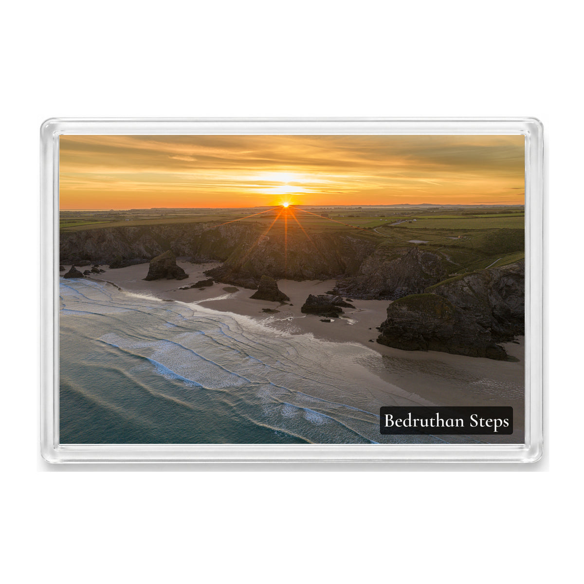 Bedruthan Steps fridge magnet showing the beach and sea stacks at low tide under a yellow and orange solstice sunrise