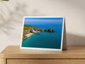 Premium A5 greeting card showing Padstow Lifeboat Station and its slipway at Mother Ivey’s Bay beside turquoise water and rocky islets