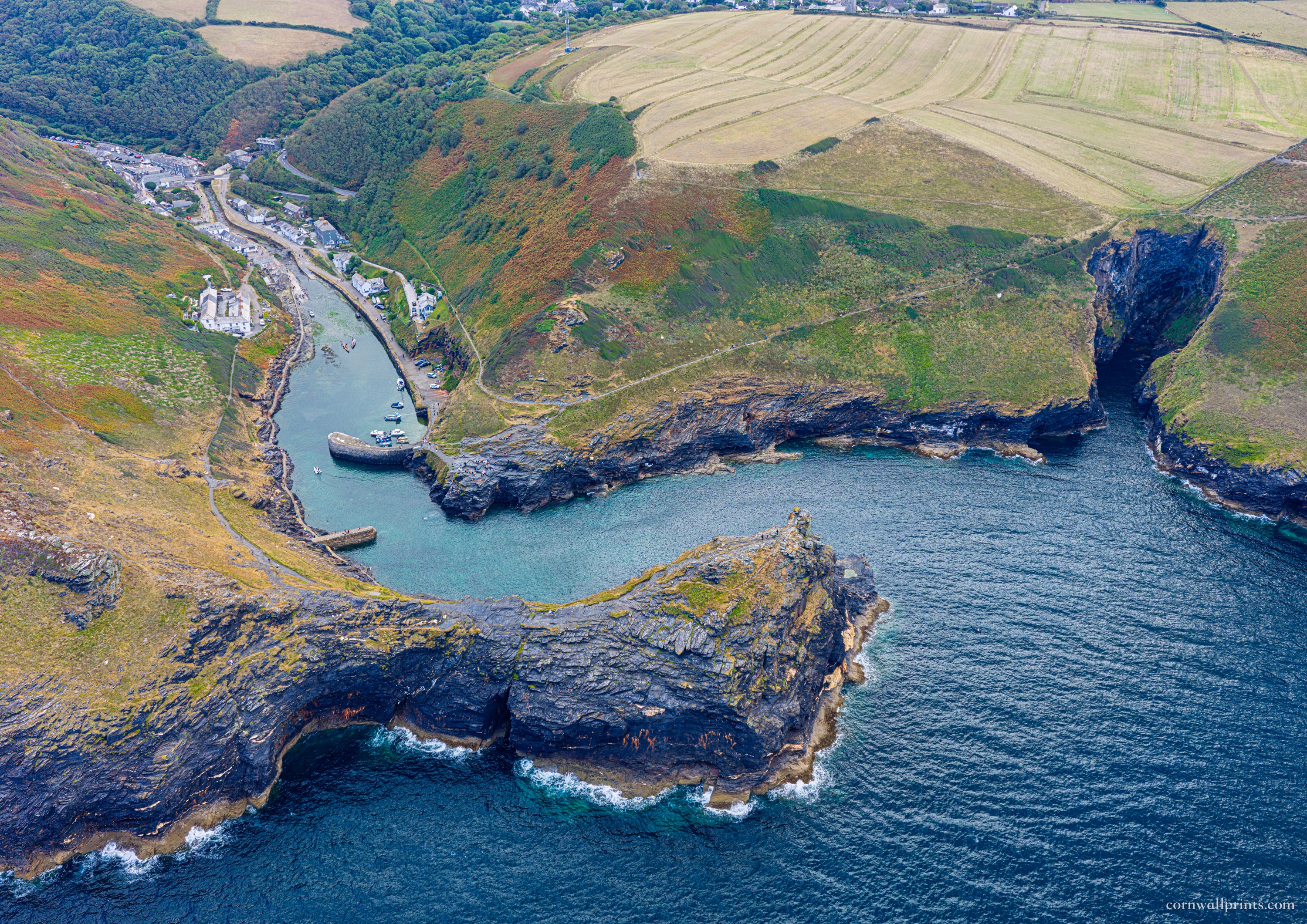 Aerial view across Boscastle harbour entrance, rugged headlands and sheltered inlet