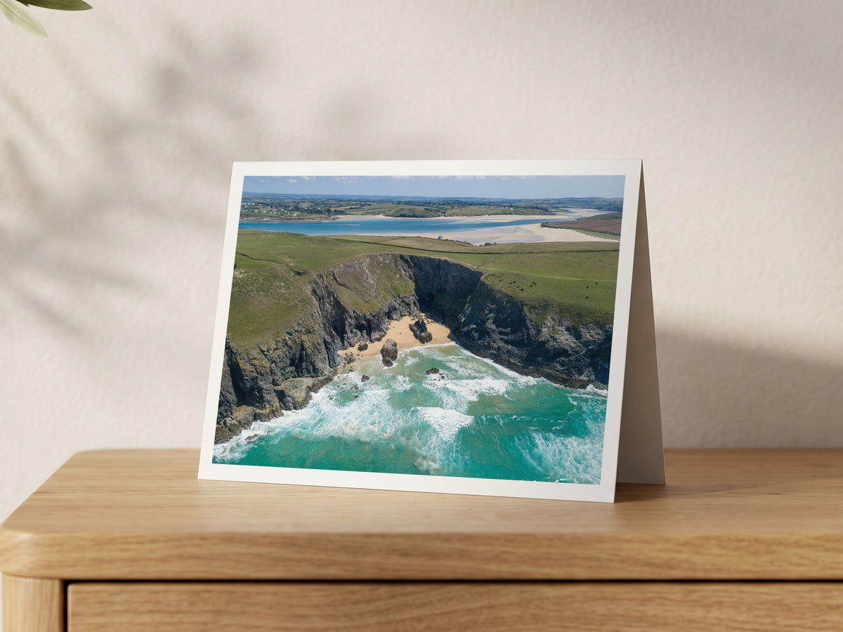 Premium A5 greeting card showing the cliff-enclosed cove of Butterhole Beach with surf and the Camel Estuary beyond