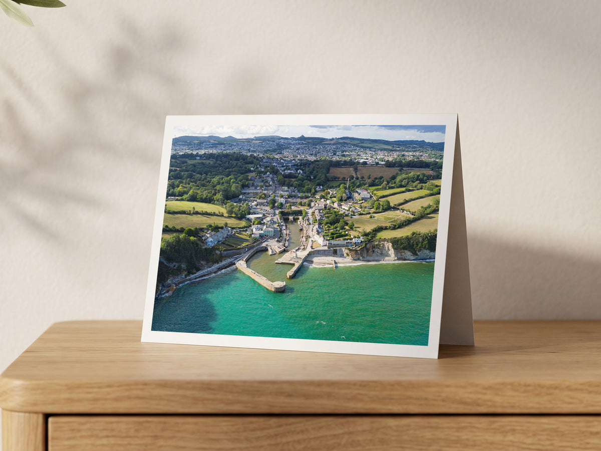 Premium A5 greeting card showing Charlestown harbour and turquoise sea, with St Austell and the Sky Tip beyond