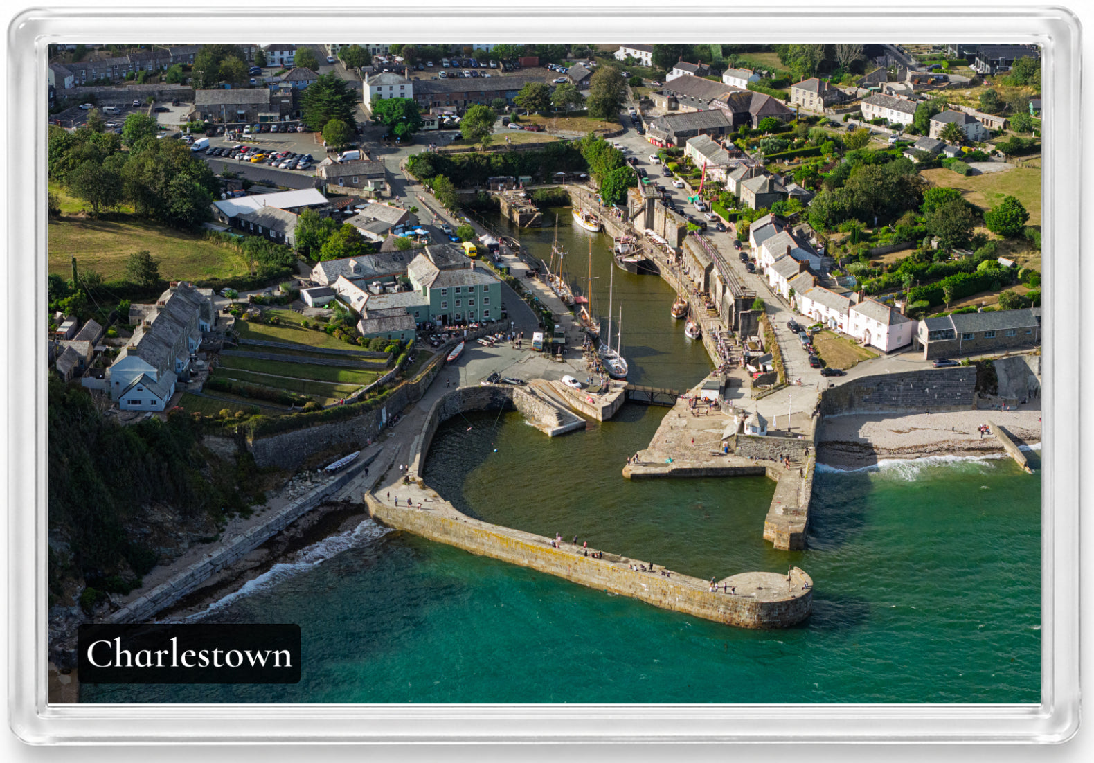 Charlestown fridge magnet showing tall ships and stone piers with muted harbour water contrasting against the turquoise sea
