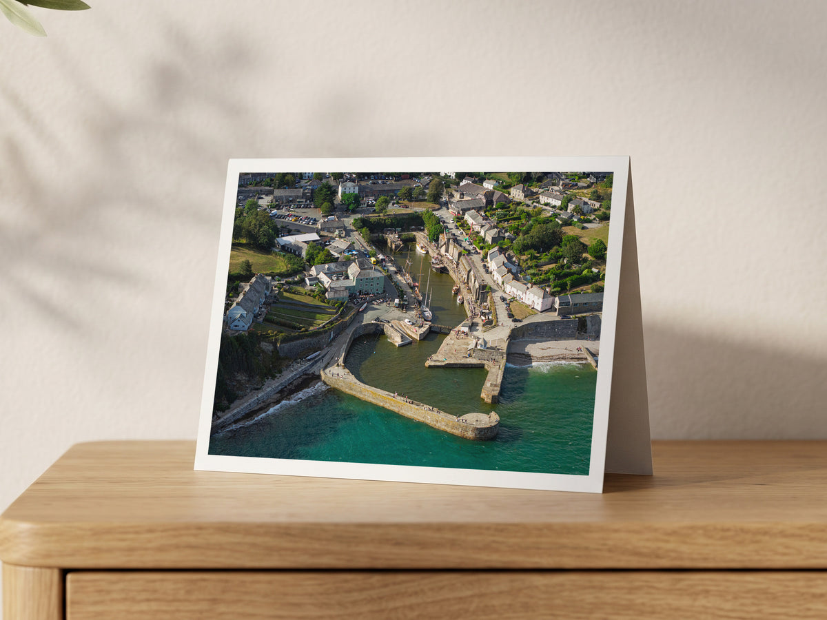 Premium A5 greeting card showing traditional sailing ships moored inside Charlestown harbour beside turquoise sea