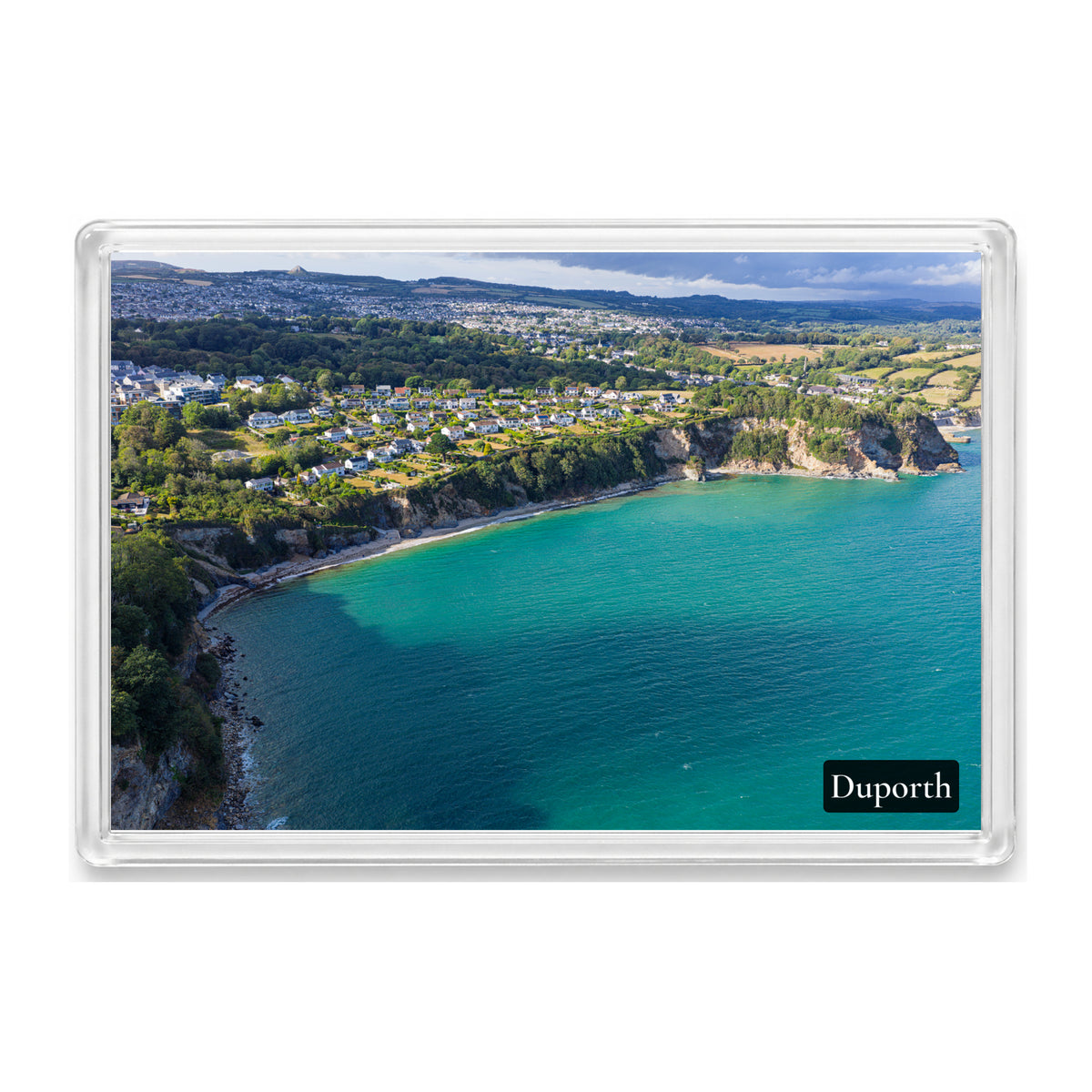 Duporth Beach fridge magnet showing turquoise water and the sand-and-pebble shore below wooded cliffs, with St Austell beyond