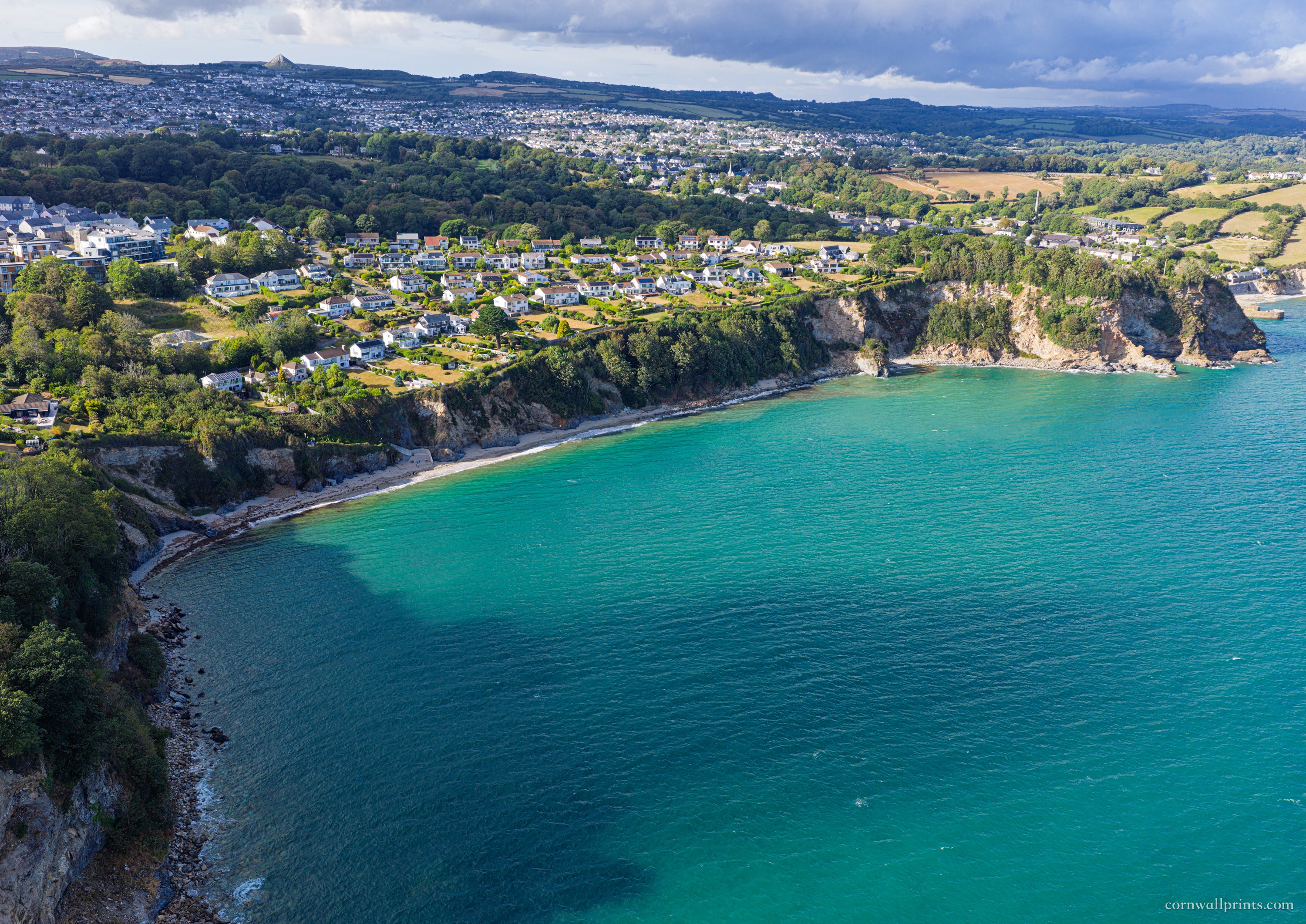 Aerial view across Duporth Beach and turquoise St Austell Bay towards coastal homes, St Austell and the Sky Tip