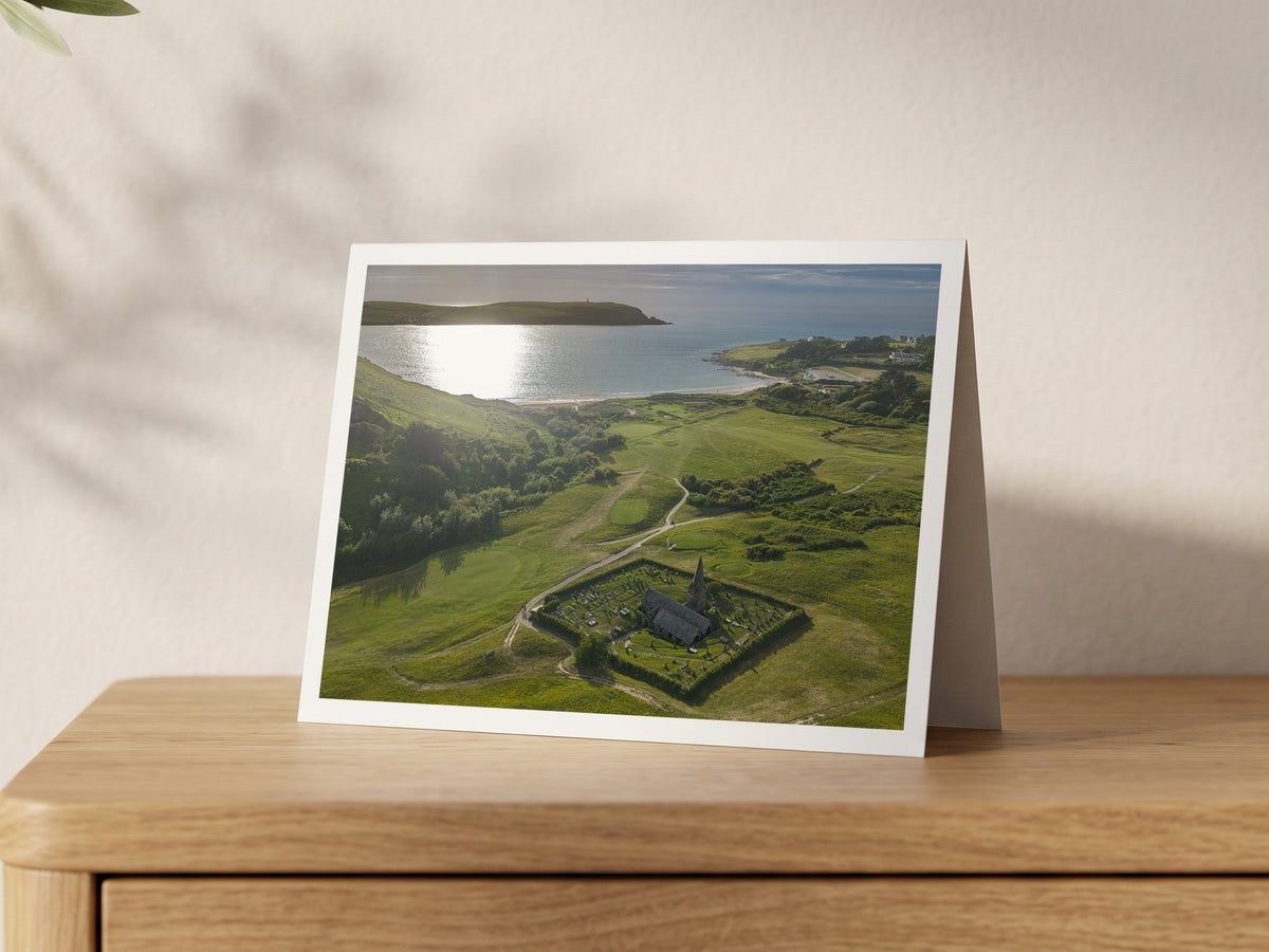 Premium A5 greeting card showing St Enodoc Church in its churchyard with sunlight on the Camel Estuary