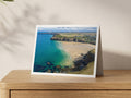Premium A5 greeting card showing Mawgan Porth beach at low tide with emerald shallows and dark reefs