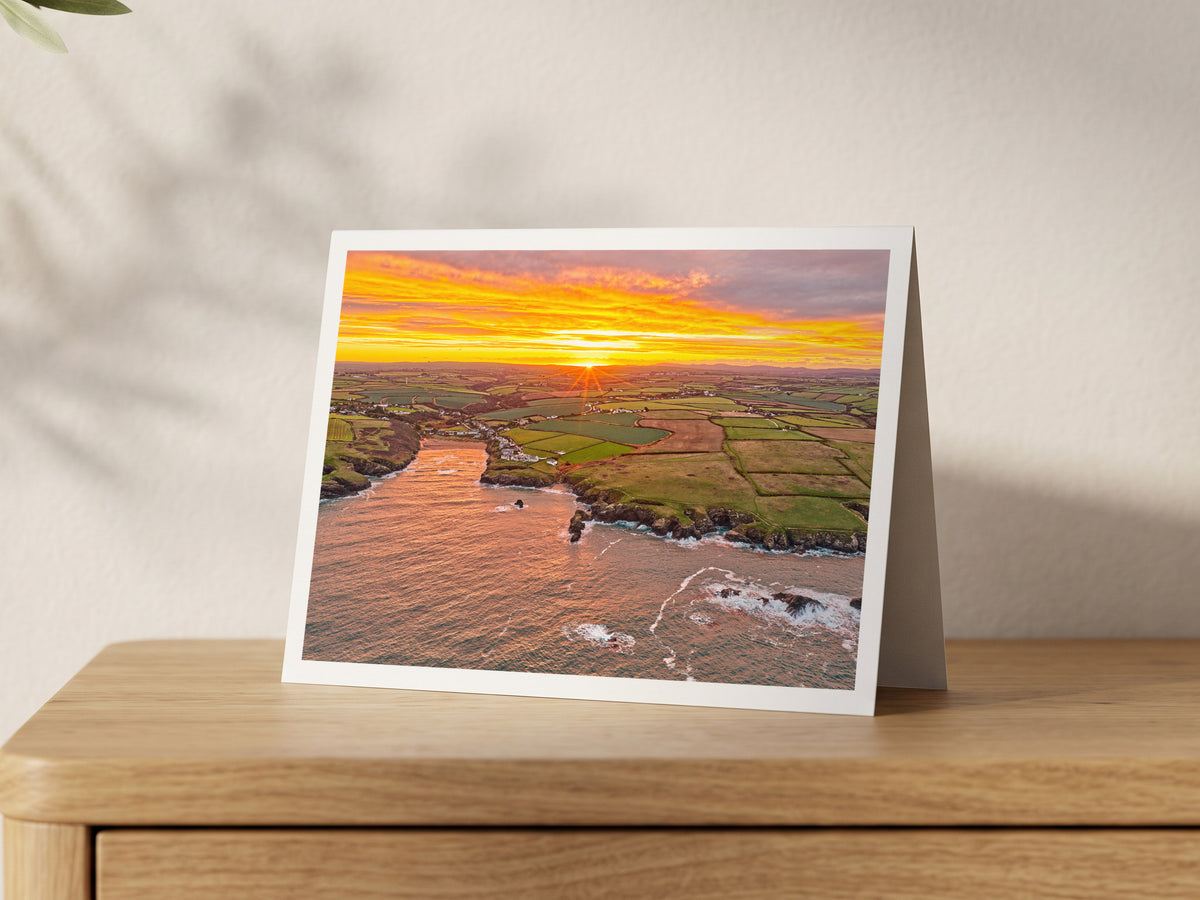 Premium A5 greeting card showing sun rays over Porthcothan Bay at an autumn sunrise