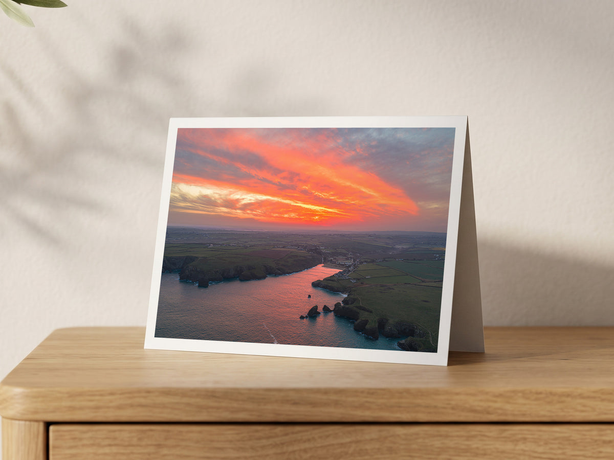 Premium A5 greeting card showing a red sunrise reflected in Porthcothan Bay at high tide