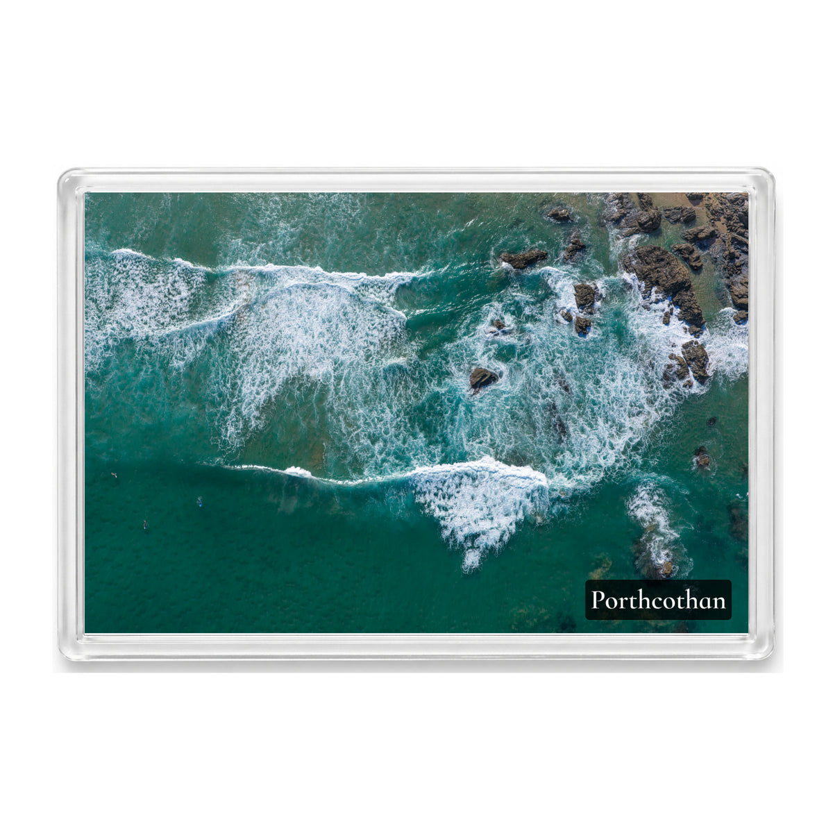 Porthcothan fridge magnet showing three surfers waiting in clear, bright water beside the rocks, seen from directly above