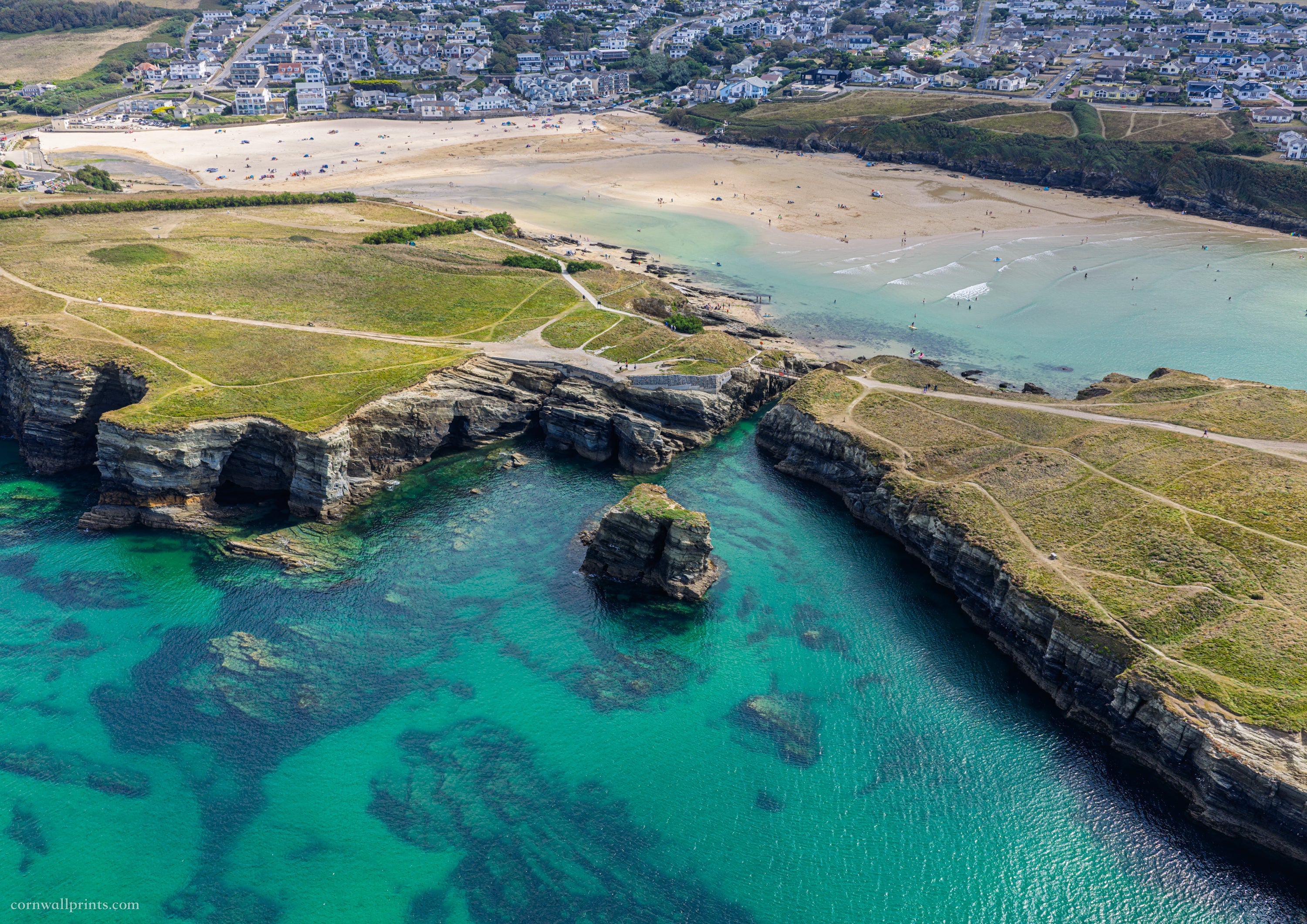 Aerial view from Whipsiderry over turquoise water, Porth Island footbridge and Porth Beach