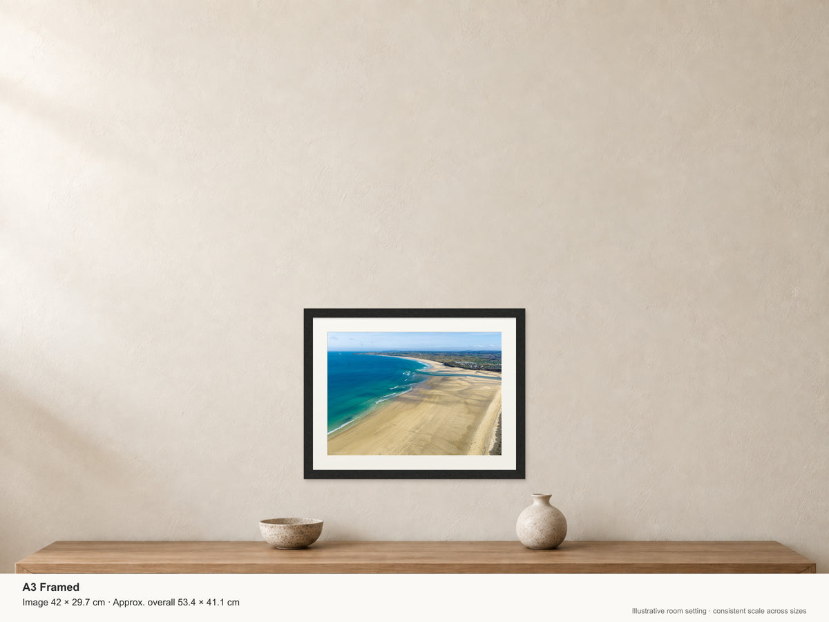 Porthkidney Sands at mid-to-low tide, looking across Hayle Estuary mouth along the expansive beaches to distant Godrevy Lighthouse — A3 22mm black stained frame and 35mm mount. Illustrative room view with dimensions.