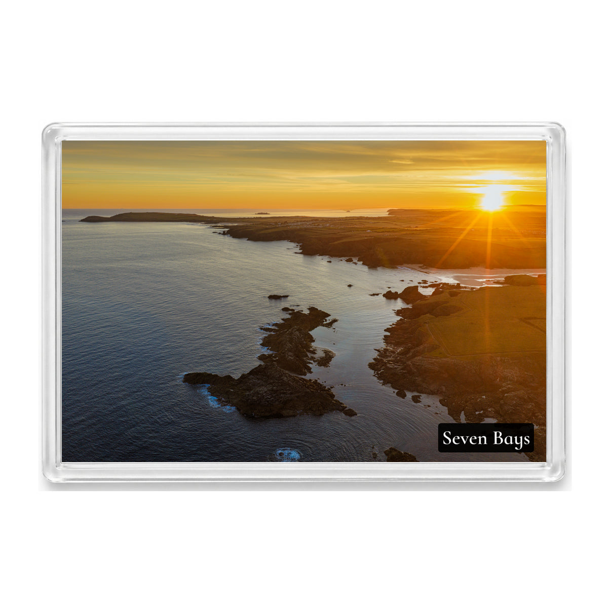 Clear acrylic fridge magnet showing golden summer solstice sunrise along the Seven Bays coast towards Trevose Head, labelled Seven Bays.