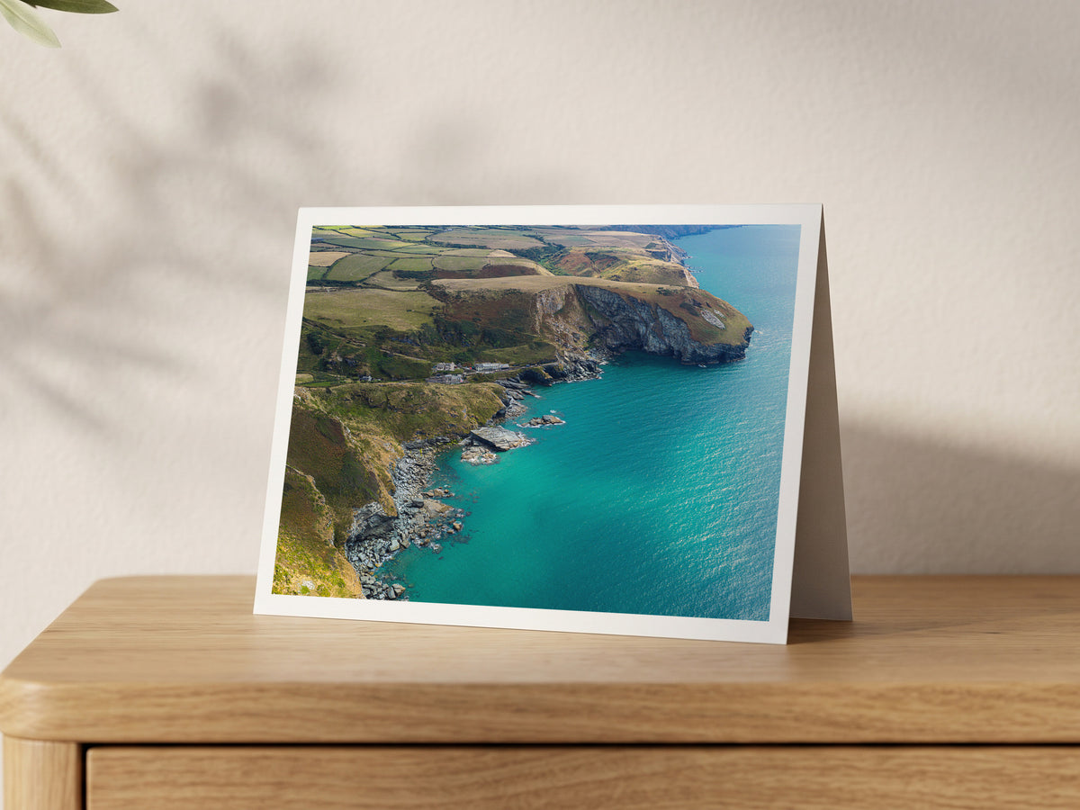 Premium A5 greeting card showing Trebarwith Strand cliffs, turquoise water and clifftop fields
