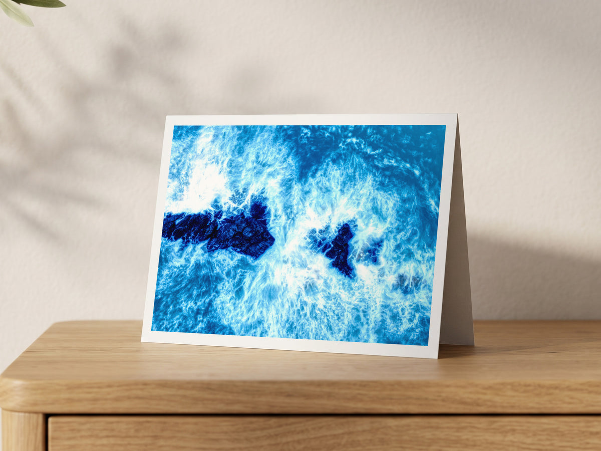 Premium A5 greeting card showing blue winter surf flowing over the Trescore rocks at Porthcothan