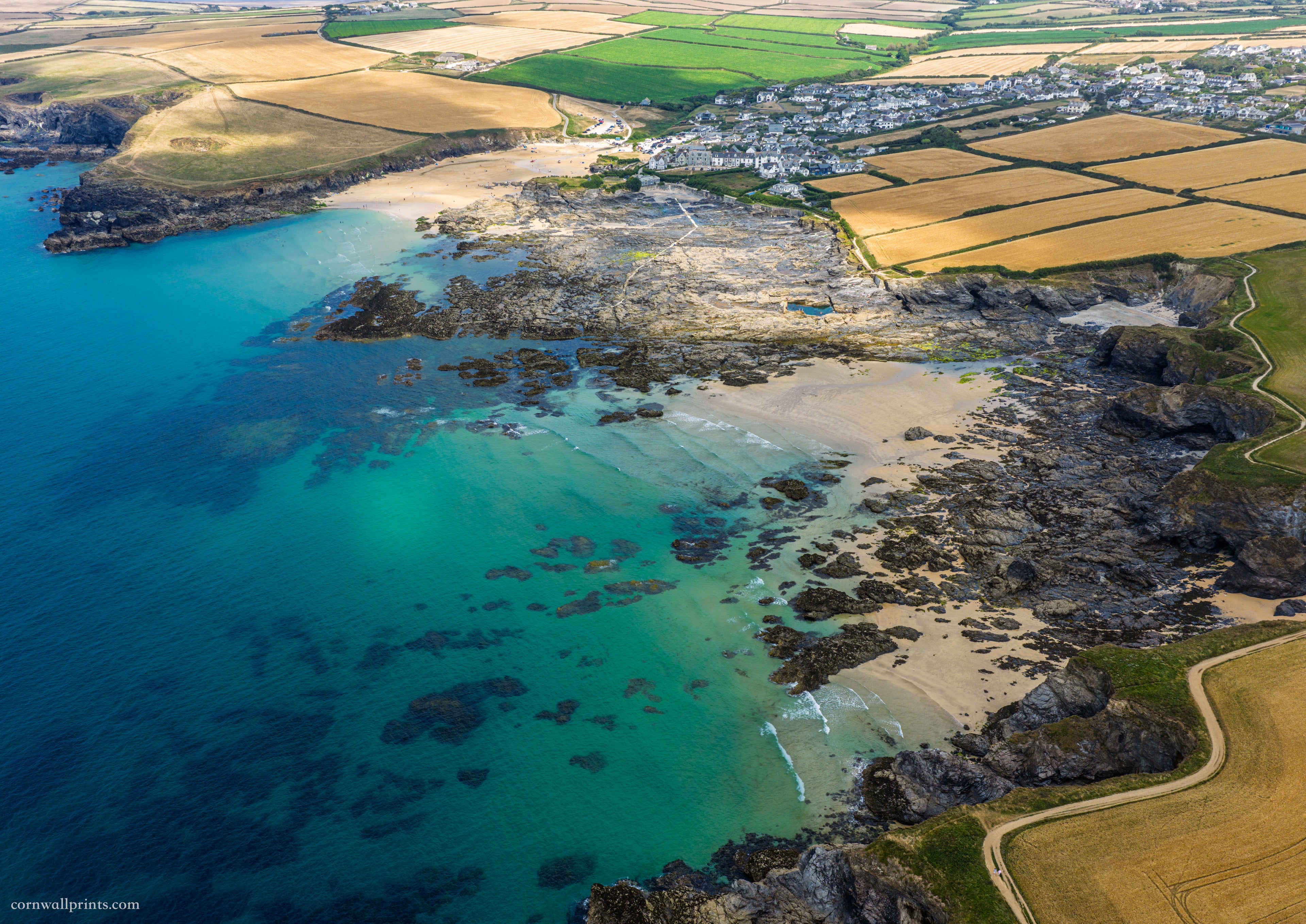 Aerial view from the Harlyn side across Newtrain Bay and turquoise water to Trevone Bay, sea pool and Round Hole