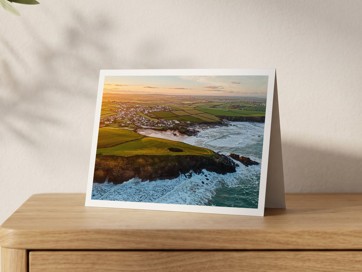 Premium A5 greeting card showing Round Hole blowhole at Trevone in warm sunrise light
