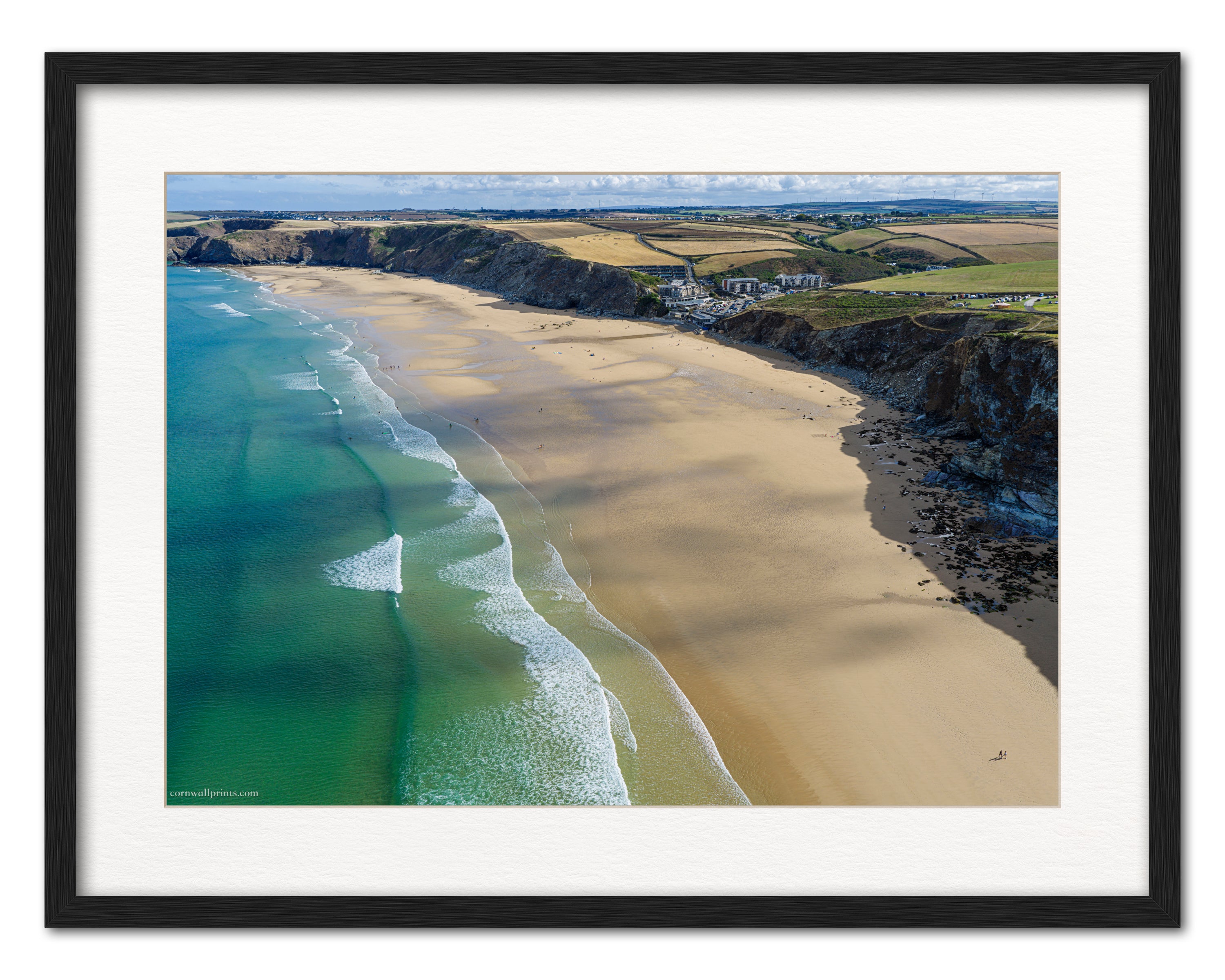 Watergate Bay low-tide aerial photograph displayed in a black frame with white mount