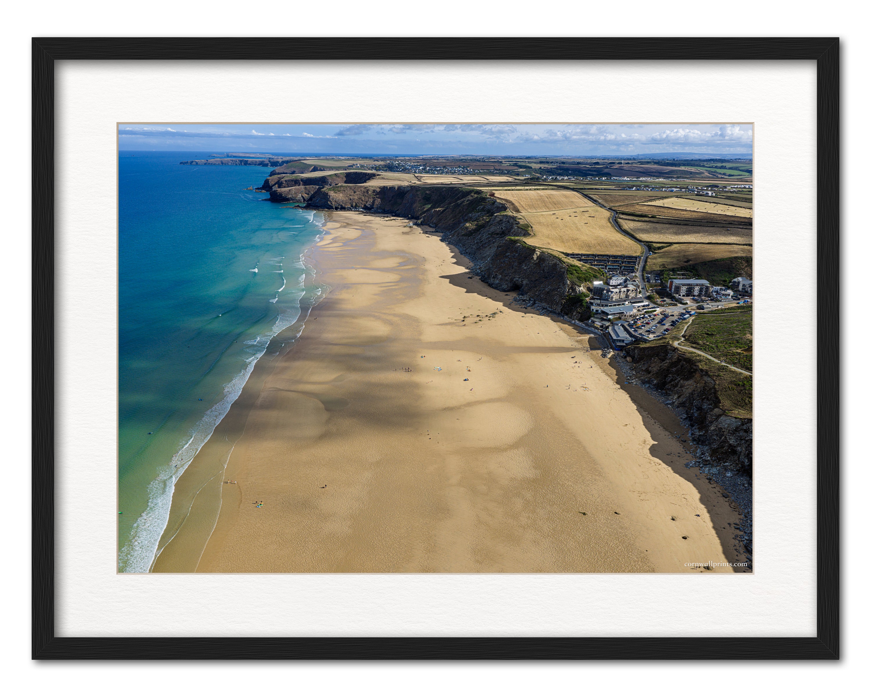 Watergate Bay aerial photograph looking north along the beach, displayed in a black frame with white mount