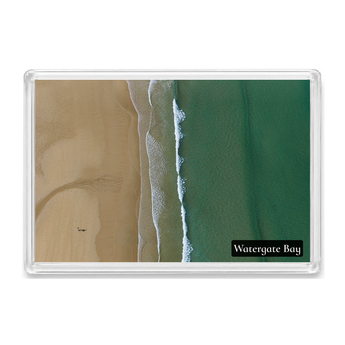 Watergate Bay fridge magnet showing turquoise and emerald water meeting textured sand along lines of white surf, from directly above