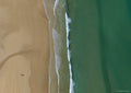 Top-down aerial view of Watergate Bay with textured sand, white surf and smooth turquoise-green water