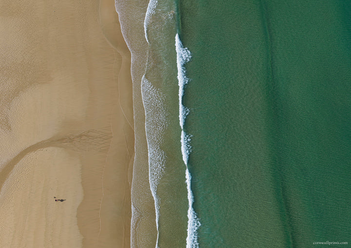 Top-down aerial view of Watergate Bay with textured sand, white surf and smooth turquoise-green water