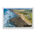 Widemouth Bay fridge magnet showing long lines of breaking surf beside rock shelves, with the bay and village leading north to Bude