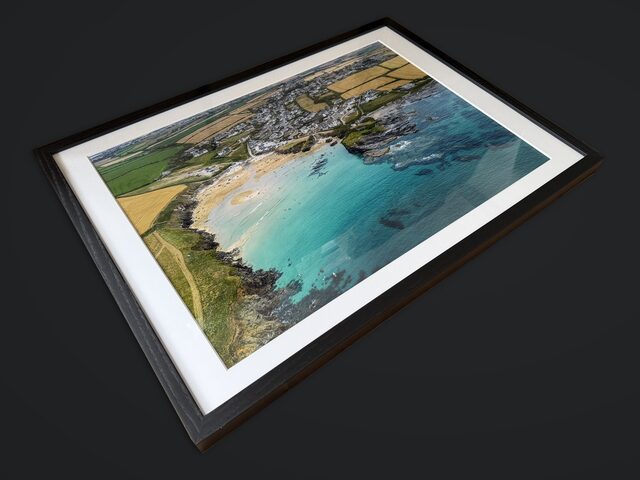 The framed Trevone Bay print at an angle, showing the depth of the black frame